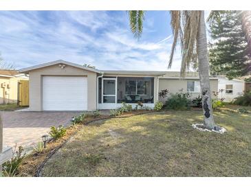 Updated bungalow style home with a screened porch, new landscaping, and a paved driveway at 7014 Ivanhoe Dr, Port Richey, FL 34668
