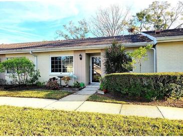 Attractive exterior of a light beige single-story home with well-manicured landscaping at 1000 Dunrobin Dr # C, Palm Harbor, FL 34684