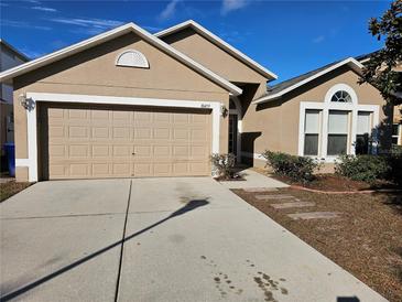 House exterior featuring a two-car garage and well-maintained landscaping at 10459 Fly Fishing St, Riverview, FL 33569