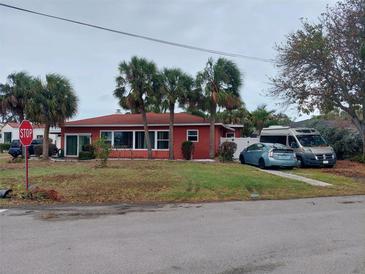 Red house with palm trees and driveway, located on a corner lot at 15806 Redington Dr, Redington Beach, FL 33708