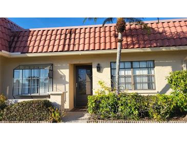 Front view of a condo with tile roof and landscaping at 19029 Us Highway 19 N # 23C, Clearwater, FL 33764