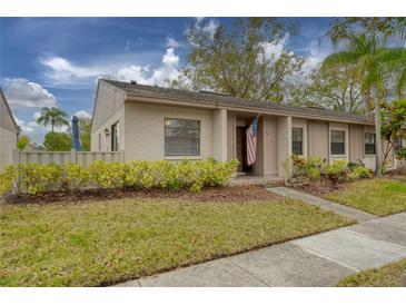 Exterior view of a charming condo with well-manicured landscaping and carport at 20 Sylvia Pl, Oldsmar, FL 34677