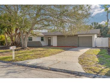 Updated single story home with gray stone facade and landscaped yard at 2215 Cedar Dr, Dunedin, FL 34698