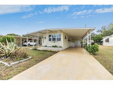 Mobile home with carport, landscaped yard, and paved driveway at 36810 Kay Ave, Zephyrhills, FL 33542