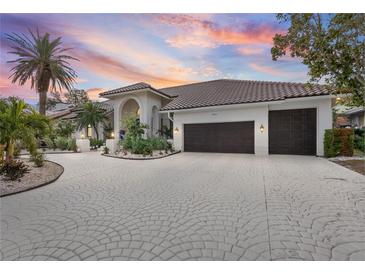 Luxury home with circular driveway, lush landscaping, and captivating sunset views at 5801 Leeland S St, St Petersburg, FL 33715