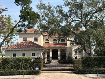 Two-story house with tile roof, gated entrance, and manicured landscaping at 6534 Bayshore Blvd, Tampa, FL 33611