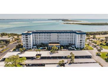 Aerial view of a waterfront condo building with parking and beautiful water views at 7 Elgin Pl # 701, Dunedin, FL 34698