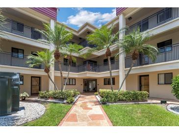 Inviting condo building with palm trees and walkway at 868 Bayway Blvd # 312, Clearwater Beach, FL 33767