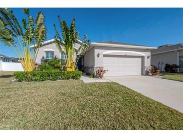 Single-story home with a two-car garage and lush landscaping at 13305 Waterleaf Garden Cir, Riverview, FL 33579