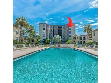 Resort-style pool and building exterior with lush landscaping at 19725 Gulf Blvd # 405, Indian Shores, FL 33785