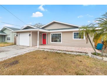 Updated home exterior with red door and landscaped yard at 210 Lee St, Oldsmar, FL 34677