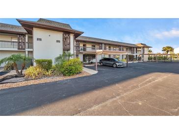 Exterior view of condo building with parking and landscaping at 5197 Silent Loop # 224, New Port Richey, FL 34652