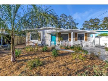 Charming bungalow with a teal door, white picket fence, and manicured landscaping at 6327 Emerson S Ave, St Petersburg, FL 33707