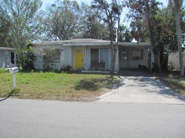 House exterior featuring a yellow door and a driveway at 6720 Hibiscus S Ave, South Pasadena, FL 33707