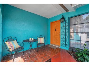 Inviting front porch with colorful chairs and a small table at 717 Carolina Ave, Tarpon Springs, FL 34689