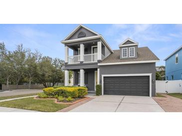 Charming two-story home featuring a second story balcony, manicured lawn, and an attached two-car garage at 7602 S Desoto St, Tampa, FL 33616