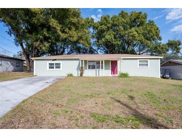 Charming light green house with a red door and well-maintained lawn at 27103 Wakefield Dr, Brooksville, FL 34602