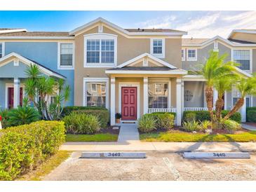 Two-story townhome with red door and landscaping at 3440 Santa Rita Ln, Land O Lakes, FL 34639