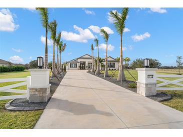 White two-story house with palm trees and a long driveway at 3571 Recurve Cir, Sarasota, FL 34240