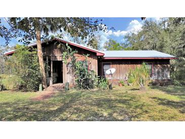 Rustic wood home with red trim, screened porch, and satellite dish at 4001 Keene Rd, Plant City, FL 33565