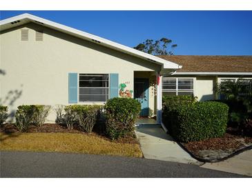 Cute Florida home with light-colored siding, manicured landscaping, and a walkway to the entrance at 407 Lake Point Ct # 4E, Sun City Center, FL 33573