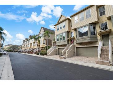 Row of charming townhouses with attached garages and lush landscaping at 4334 Spinnaker Cove Ln, Tampa, FL 33615