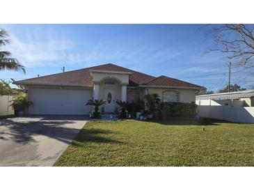 Single-story house with a red tile roof, attached garage, and well-maintained lawn at 6190 107Th N Ave, Pinellas Park, FL 33782