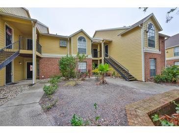 Exterior view of a two-story condo building with brick and siding at 8609 Mallard Reserve Dr # 103, Tampa, FL 33614