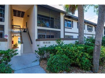 Exterior view of condo building with stairs and landscaping at 19505 Quesada Ave # O105, Port Charlotte, FL 33948