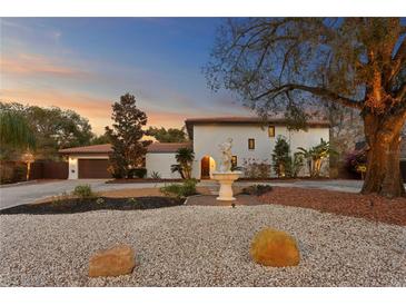 Stunning home features a lovely front yard, beautiful landscaping, and a charming water fountain at 403 Weeburn Rd, Temple Terrace, FL 33617