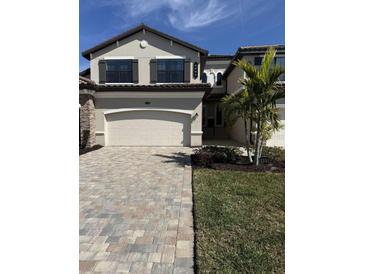 Two-story townhome with paver driveway and landscaping at 6005 Worsham Ln # 102, Bradenton, FL 34211