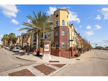 Exterior of a yellow building with palm trees and street view at 1910 E Palm Ave # 8314, Tampa, FL 33605