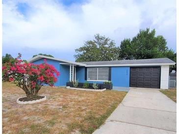 Cute blue house with a well-maintained lawn and driveway at 3546 Cheswick Dr, Holiday, FL 34691