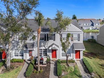 Two-story townhome with red door, landscaping, and a palm tree at 388 Countryside Key Blvd, Oldsmar, FL 34677