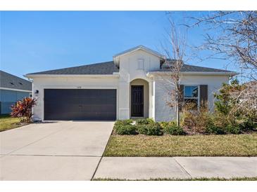 Single-story home with dark gray garage door and landscaped yard at 5658 Del Coronado Dr, Apollo Beach, FL 33572