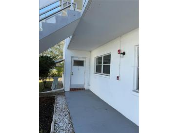 Exterior view of condo building, showing walkway, landscaping, and building exterior at 5895 18Th N St # 9, St Petersburg, FL 33714