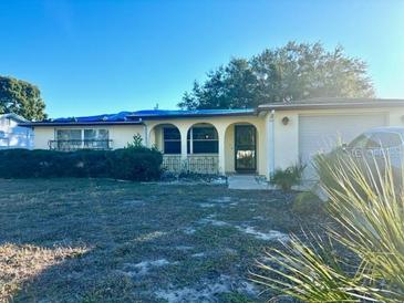 Ranch style home with carport and mature landscaping at 7614 Karen Dr, Port Richey, FL 34668