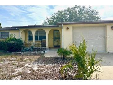 Ranch-style home with attached garage and mature landscaping at 7614 Karen Dr, Port Richey, FL 34668