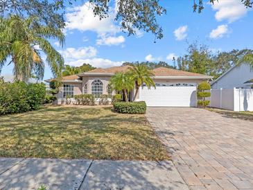 Single-story home with a paved driveway and lush landscaping at 805 Anchors Way, Tarpon Springs, FL 34689