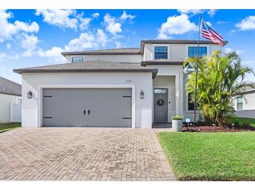 Charming two-story home featuring an attached two-car garage, brick paver driveway and well-manicured lawn at 1179 Lawnview Ter, Trinity, FL 34655