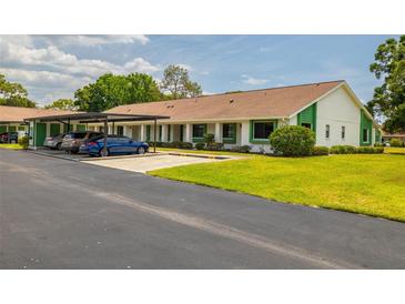 Front view of condo building with carport and landscaping at 2545 Laurelwood Dr # 9C, Clearwater, FL 33763