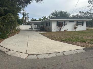 White single story home with a long driveway and mature landscaping at 3553 Center Cir, Largo, FL 33774
