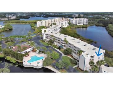 Aerial view of waterfront condo building with pool and lush landscaping at 6315 Shoreline Dr # 3208, St Petersburg, FL 33708
