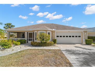 Single-story home with a two-car garage and landscaped front yard at 1311 Caloosa Lake Ct, Sun City Center, FL 33573