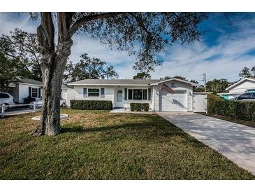 Charming single-story home with a well-manicured lawn, garage, and American flag displayed at 1570 S Michigan Ave, Clearwater, FL 33756