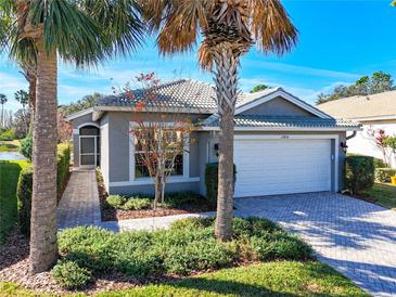 Single-story home with white garage door and landscaped yard at 15856 Cobble Mill Dr, Wimauma, FL 33598