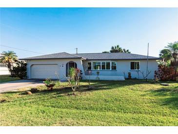 Single-story home with a gray exterior, attached garage, and well-maintained lawn at 18719 Van Nuys Cir, Port Charlotte, FL 33948