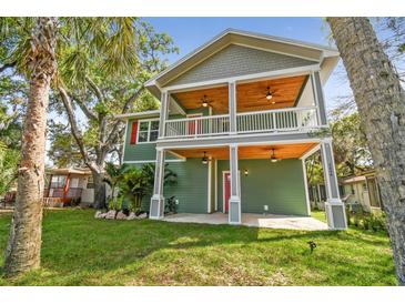 Two-story home with a covered porch, wood ceilings, and a well-manicured front lawn at 5644 Missouri Ave, New Port Richey, FL 34652