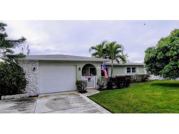 Ranch-style home with a green exterior, attached garage, and well-maintained lawn at 568 Seacrest Dr, Largo, FL 33771