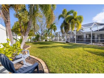 Spacious backyard with lush lawn, palm trees, and a screened pool at 5720 Venetian Ne Blvd, St Petersburg, FL 33703